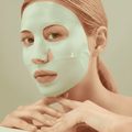 blonde vrouw met een groen collageen masker op