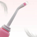 Detail van de gebogen sproeikop met roze opzetstuk en doorzichtig stofkapje