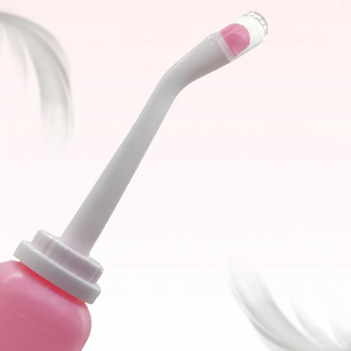 Detail van de gebogen sproeikop met roze opzetstuk en doorzichtig stofkapje