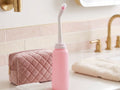Bidetfles op de wastafel naast een toilettas