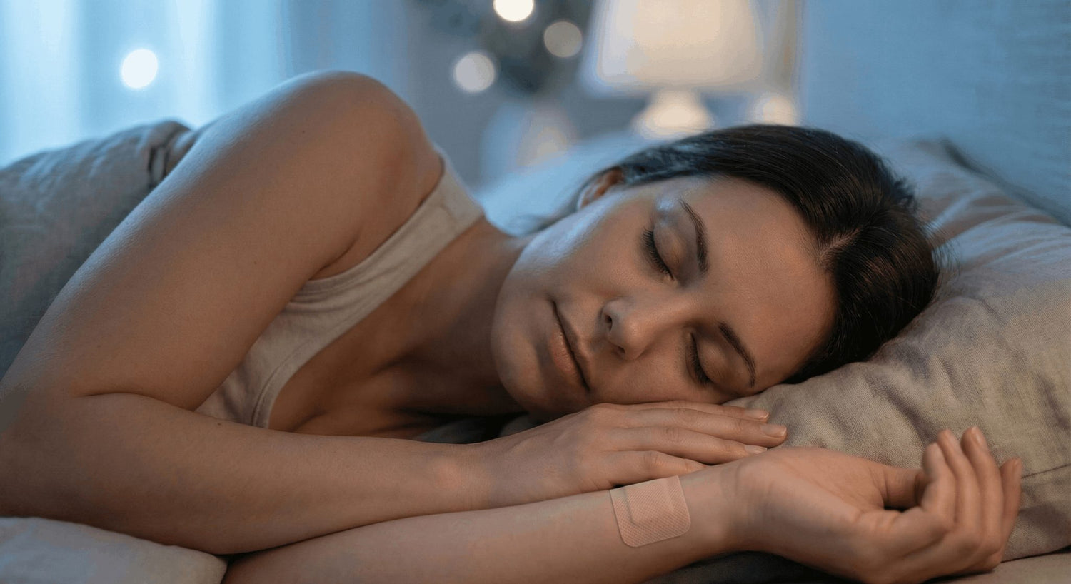 vrouw ligt te slapen met een slaappleister op de binnenkant van haar pols.